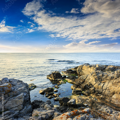 calm sea with boulders on coast