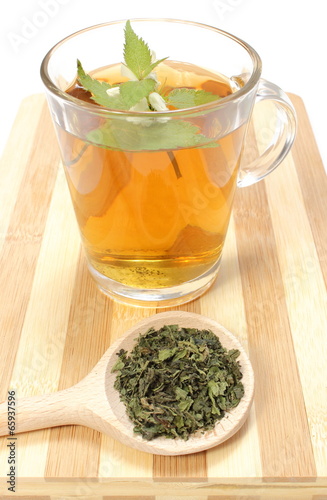 Fresh and dried nettle with cup of beverage