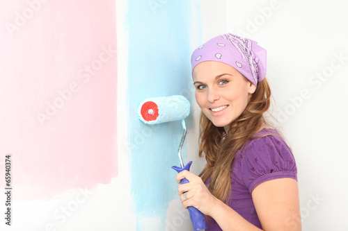 Φωτογραφία early pregnant woman deciding to paint nursery pink or blue.