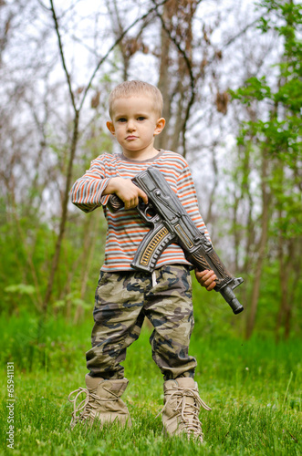 Foto Young boy posing with machine gun