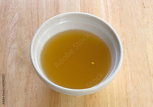 Chicken broth in an old bowl on a table
