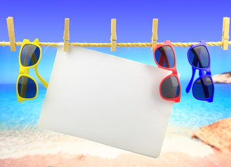 Sunglasses and banner hanging on a rope in front of the sea