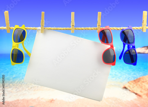 Sticker Sunglasses and banner hanging on a rope in front of the sea