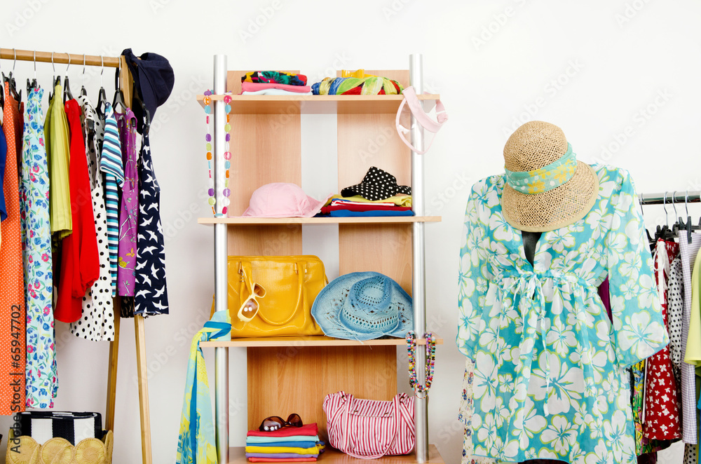 Wardrobe with summer clothes and a beach outfit on a mannequin.
