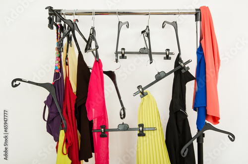 Slika na platnu Messy rack of clothes and hangers. Untidy woman wardrobe.