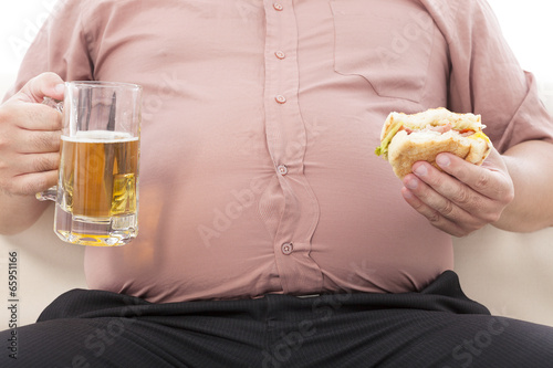 fat business man holding beer mug and hamburger photo