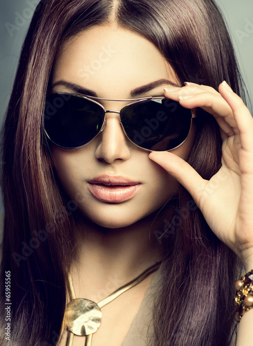 Beauty model girl with long brown hair wearing sunglasses