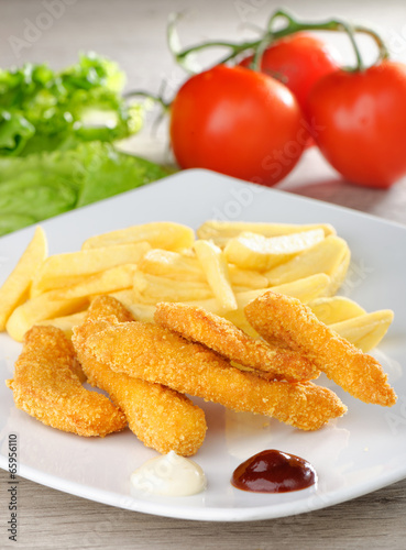 chicken nuggets/sticky fingers and french fries on a white plate