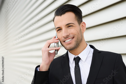 Attractive young businessman on the phone in an office building