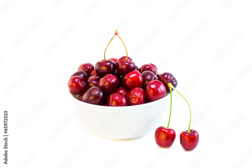 A white bowl of cherries isolated with a pair on front A white bowl of cherries isolated with a pair on front