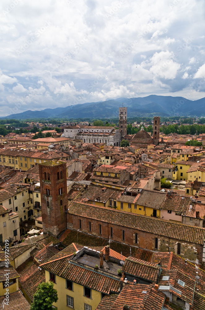 Cityscape of Lucca with cathedral and mountains in back, Tuscany