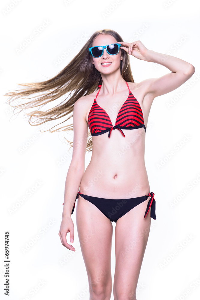 Smiling young woman in swimsuit and sunglasses isolated on white Smiling young woman in swimsuit and sunglasses isolated on white