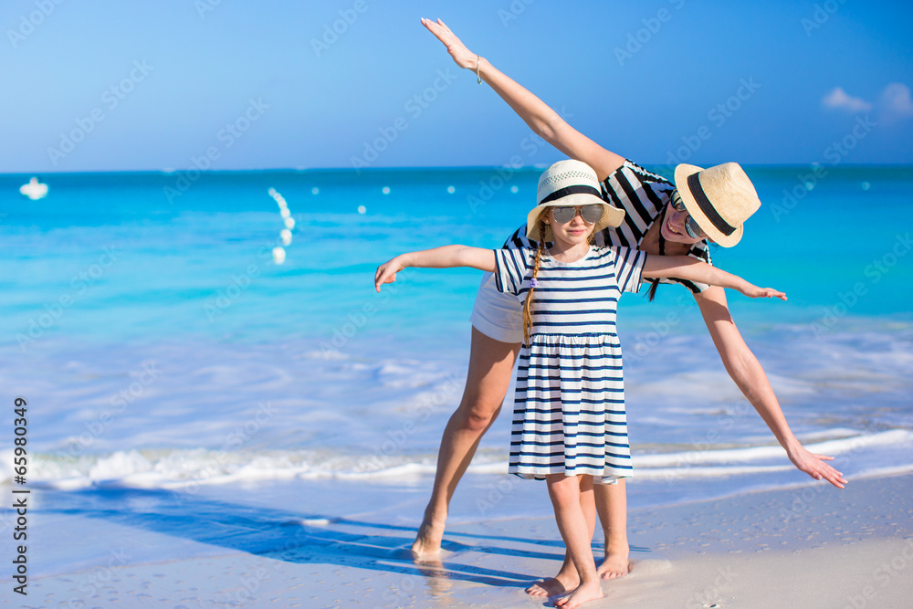Young mother with her daughter enjoy vacation on caribbean beach - obrazy, fototapety, plakaty 