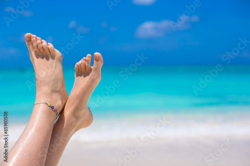 Close up of female legs on white sandy beach