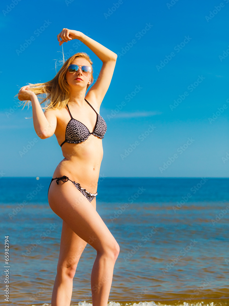 Summer vacation. Girl in bikini standing on beach Summer vacation. Girl in bikini standing on beach