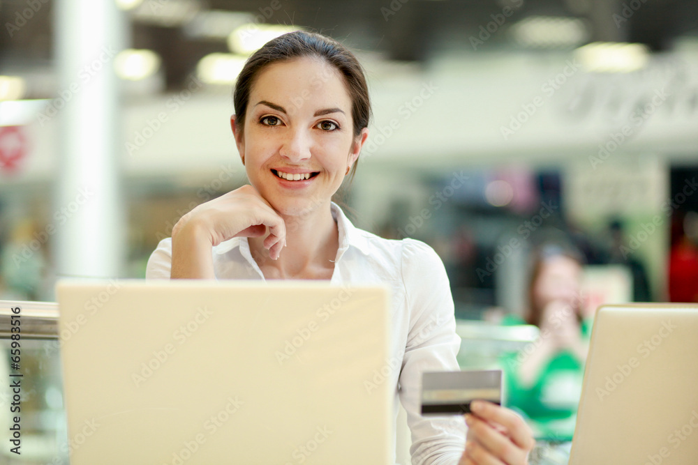 woman sitting on the desk and shopping online woman sitting on the desk and shopping online