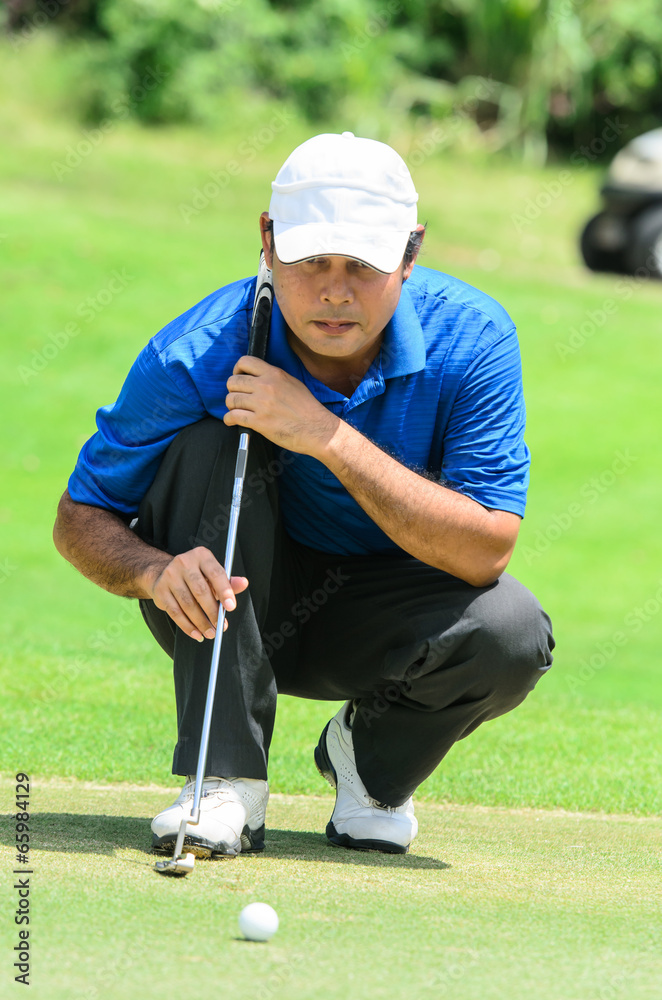 Obraz premium golf player on course putting, he aiming for his put shot
