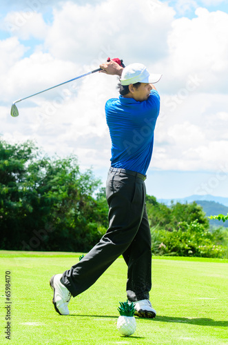 Golfer swinging his gear and hit the golf ball from tee to the f