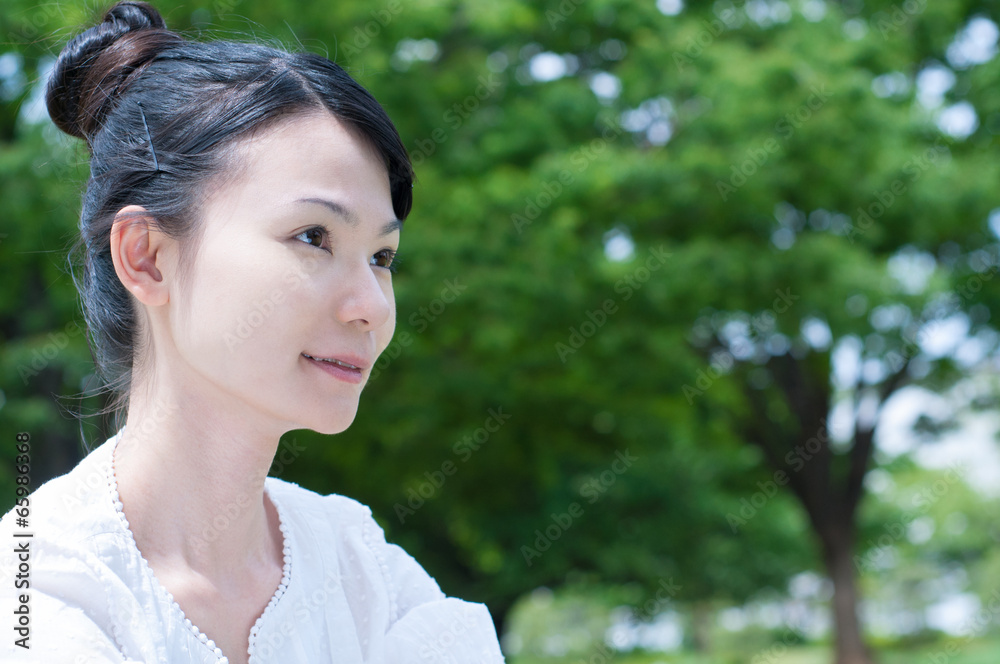 緑を背景にして考える女性 緑を背景にして考える女性