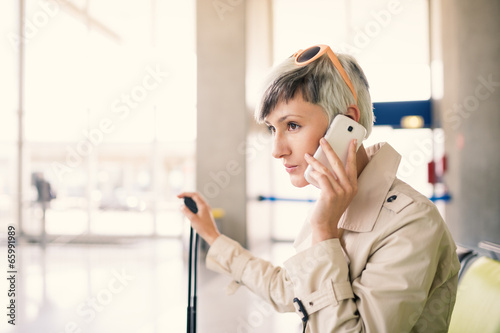 Businesswoman talking at mobile phone at Charles de Gaulle airpo photo