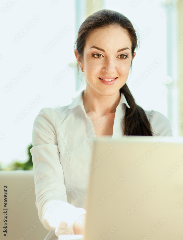 Beautiful happy smiling woman sitting on the sofa with laptop Beautiful happy smiling woman sitting on the sofa with laptop
