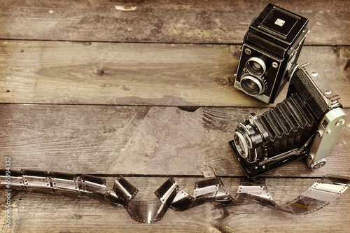 Old retro camera on vintage wooden background photo