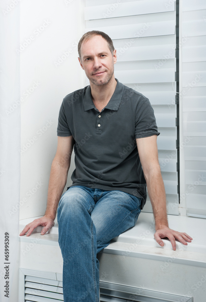 Man sitting on a white window Man sitting on a white window