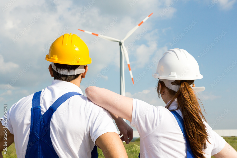 Engineers or installers looking at wind energy turbine Engineers or installers looking at wind energy turbine