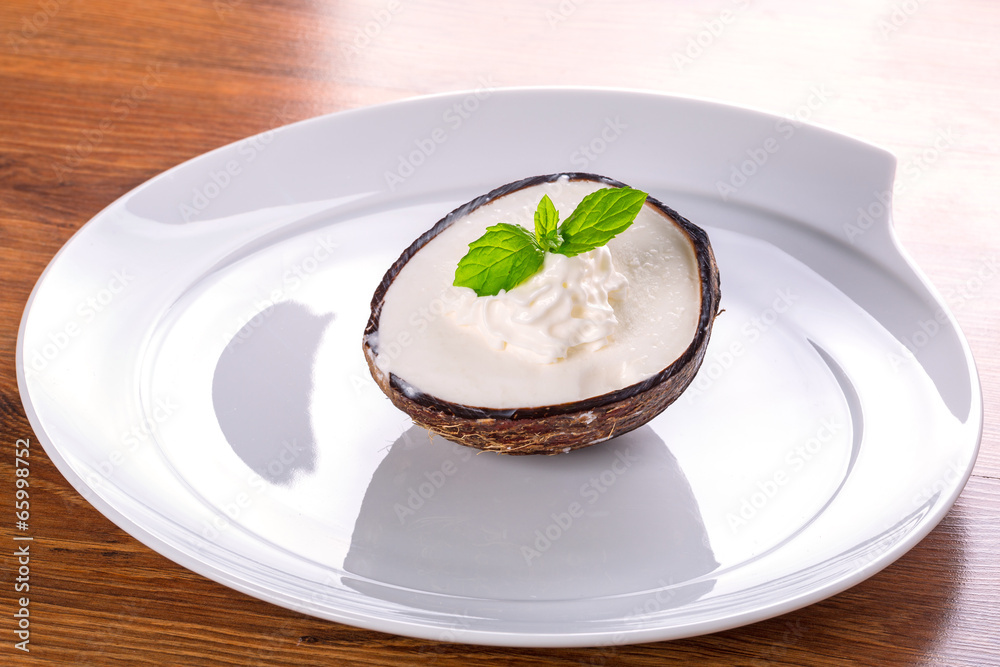 Coconut ice cream in coco shell on the plate Coconut ice cream in coco shell on the plate