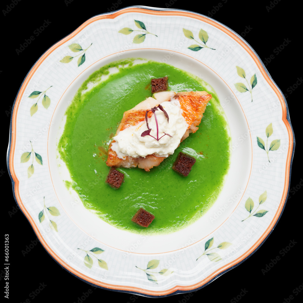 Seabass with herbs and spinach puree isolated on black Seabass with herbs and spinach puree isolated on black