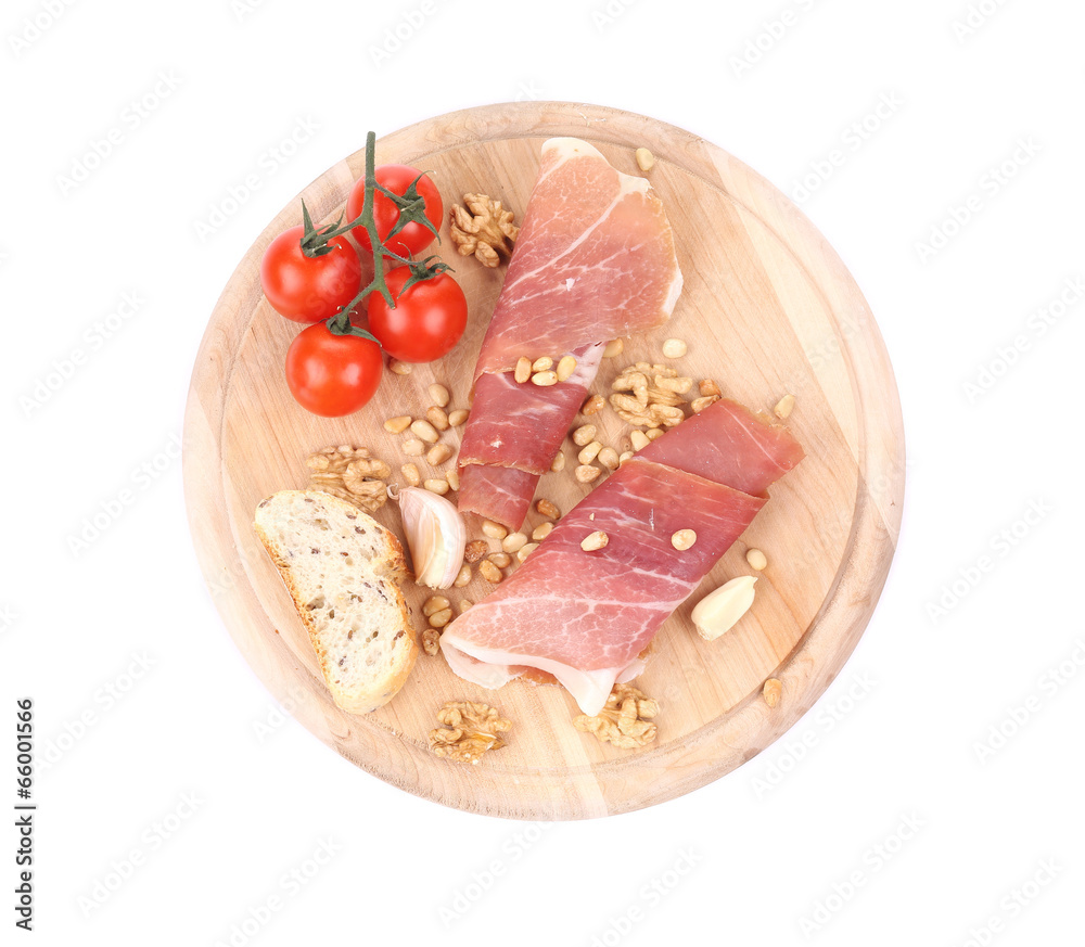 Composition of prosciutto on wooden platter.