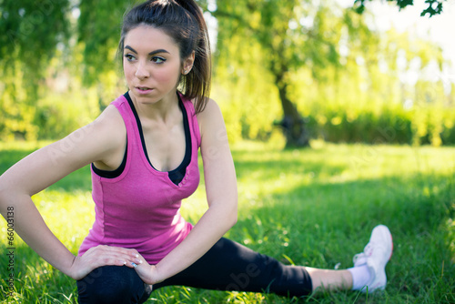 Young woman portrait stretching her legs outdoors in a park.