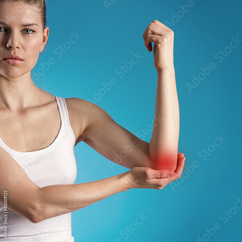 Young woman suffering from elbow pain or injury.