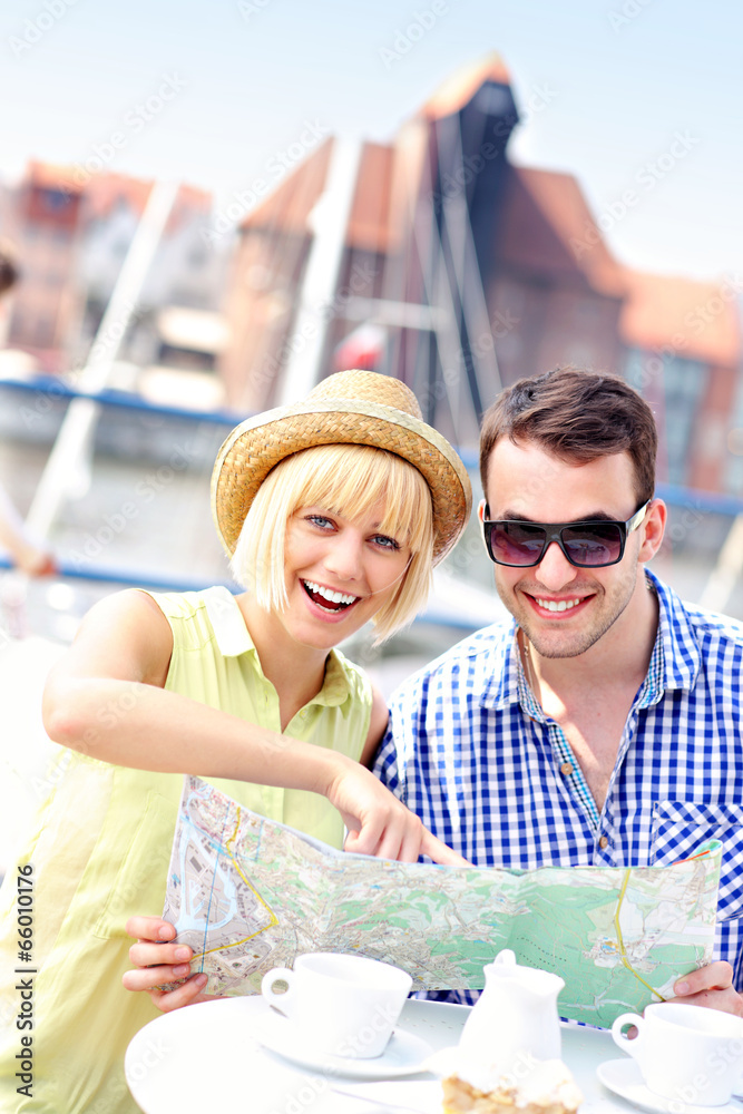 Young couple pointing at map