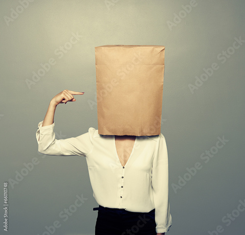 woman pointing at paper bag on the head
