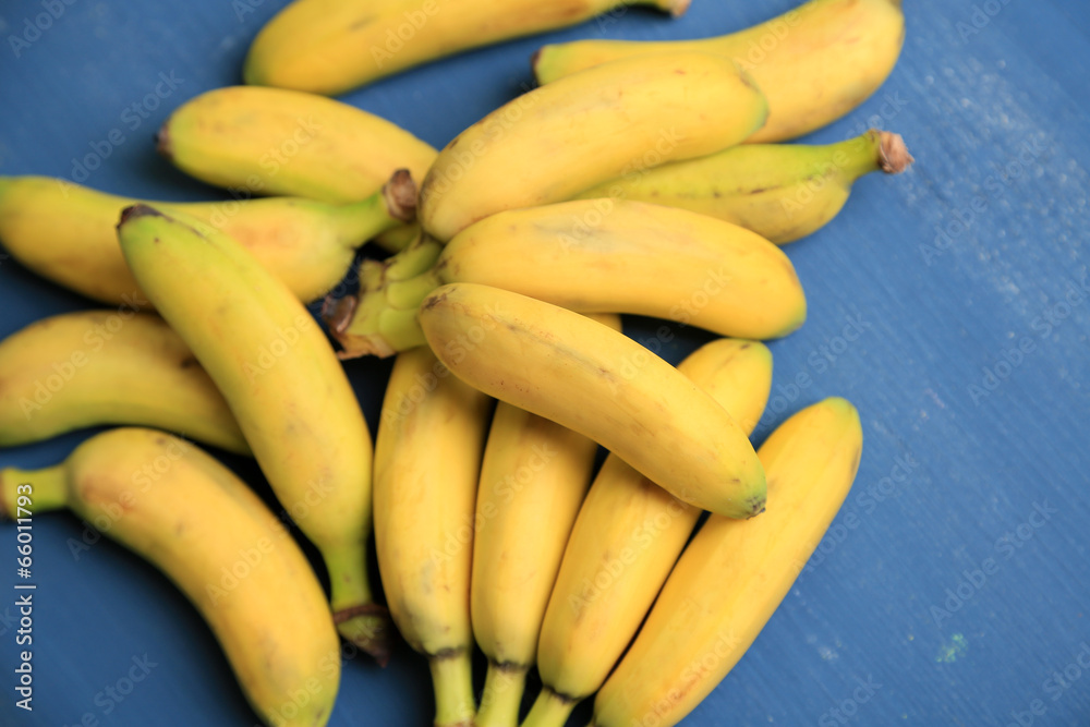 Bunch of mini bananas on color wooden background Bunch of mini bananas on color wooden background