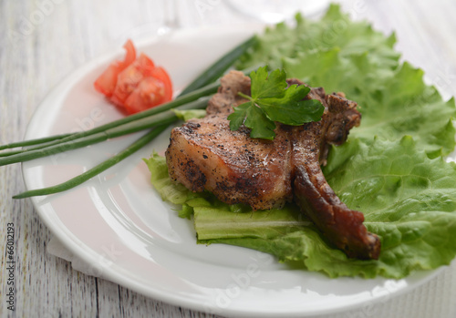 pork steak on lettuce with tomatoes and onions