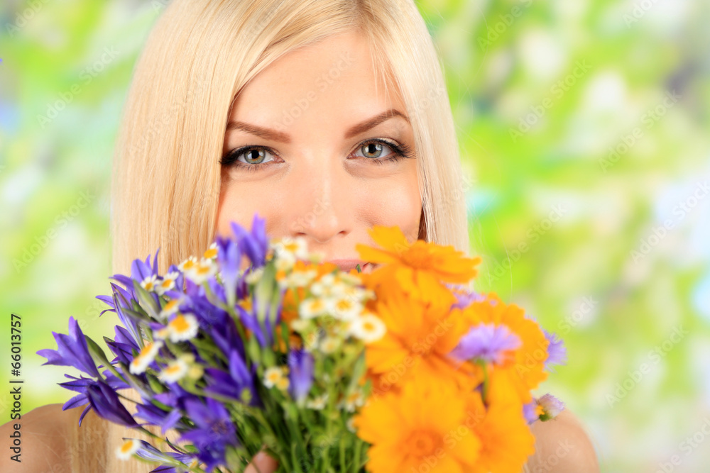 Young beautiful woman with flowers on bright background Young beautiful woman with flowers on bright background