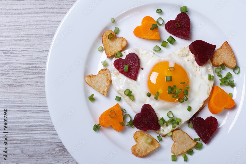 Romantic breakfast of fried hearts of vegetables and eggs