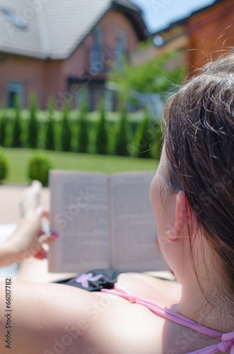 Girl reading book on garden