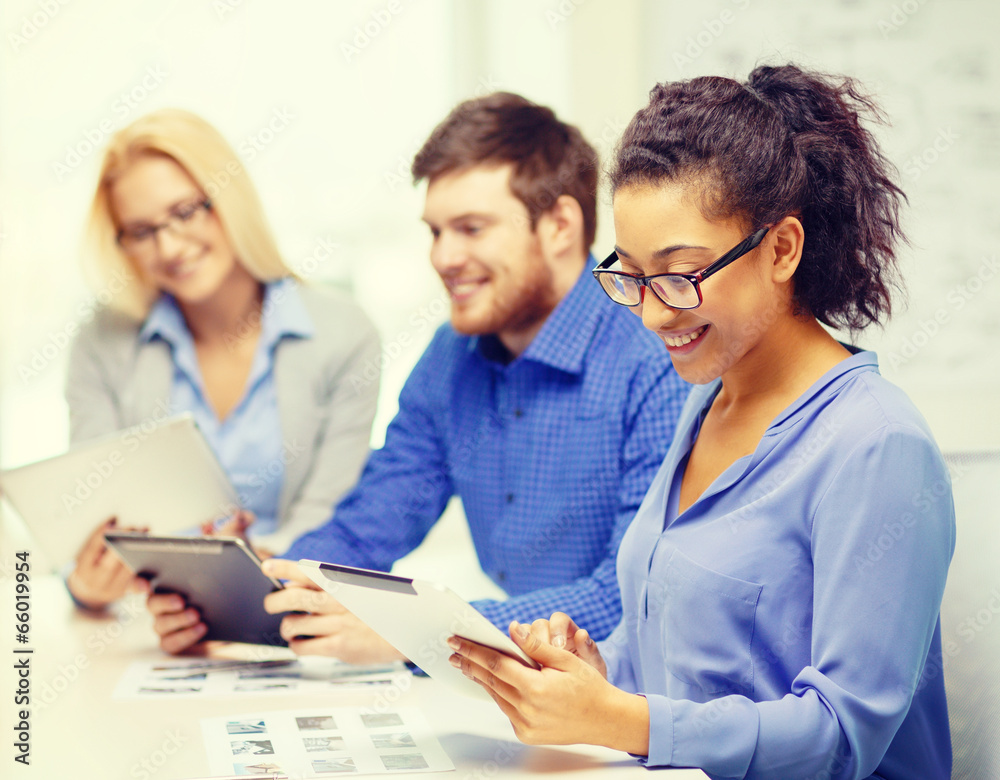 smiling team with table pc and papers working smiling team with table pc and papers working