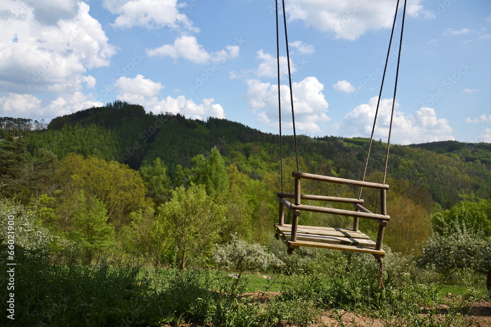 Empty wooden rope swing with nature background Empty wooden rope swing with nature background