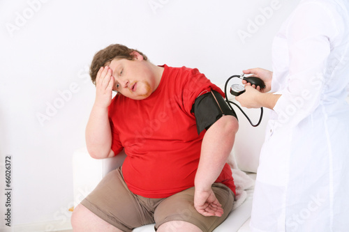 Fotografie Doctor examining  patient obesity on light background
