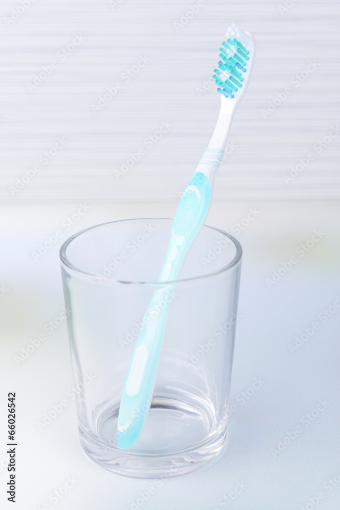 Toothbrush in glass on table on light background Toothbrush in glass on table on light background