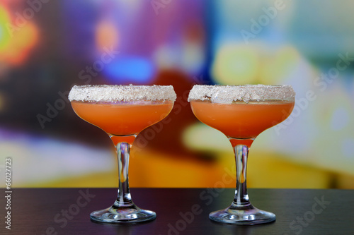 Grapefruit cocktail in glasses on bright background