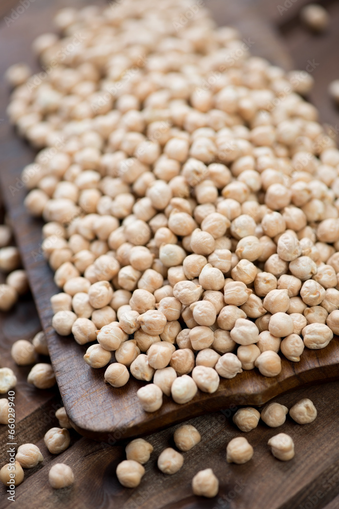 Close-up of raw chickpeas over wooden background, studio shot Close-up of raw chickpeas over wooden background, studio shot