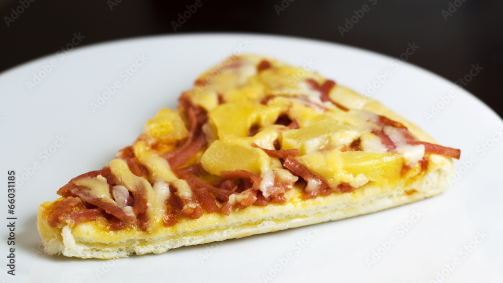 slice of fresh baked pizza hawiian on white dish slice of fresh baked pizza hawiian on white dish