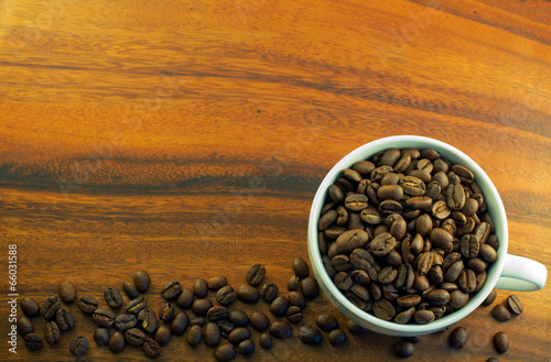 coffee beans in a cup on wooden table background