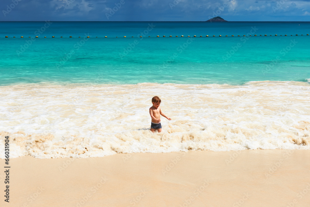 Two year old boy playing on beach