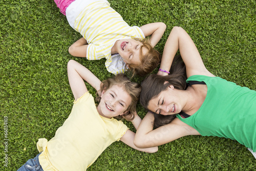 Drei Mädchen liegen im Gras